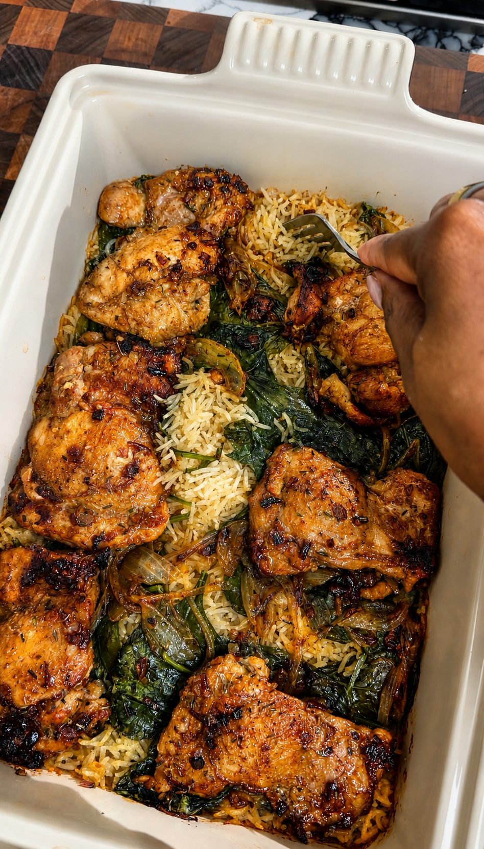 Golden brown chicken thighs baked over fluffy rice with sautéed spinach and caramelized onions in a white casserole dish, with a hand scooping into the creamy Chicken Florentine rice bake.